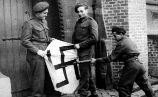 Members of the Pioneer Corps stabbing a Swastika in Brussels 1944